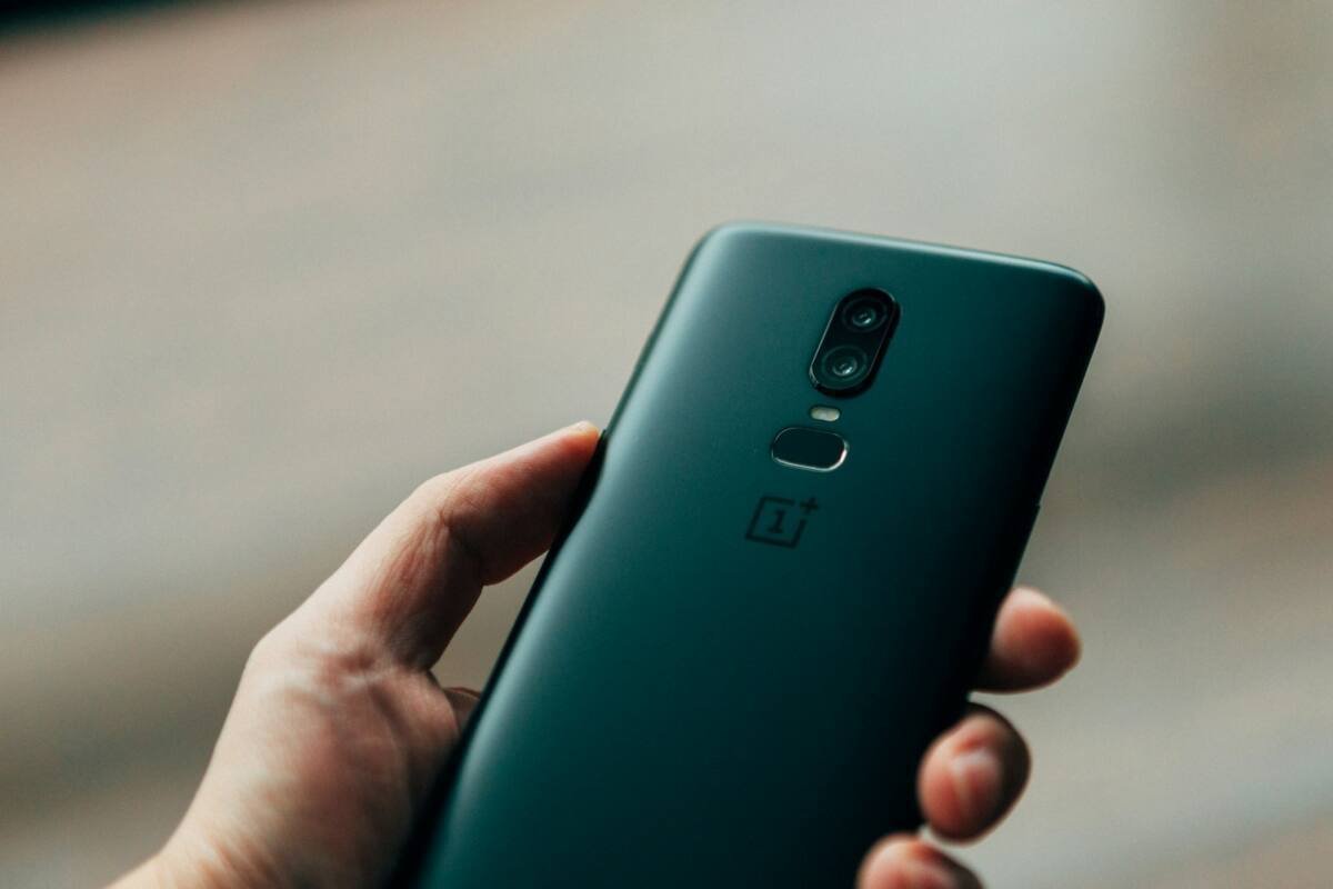 Person holding a black OnePlus Android smartphone