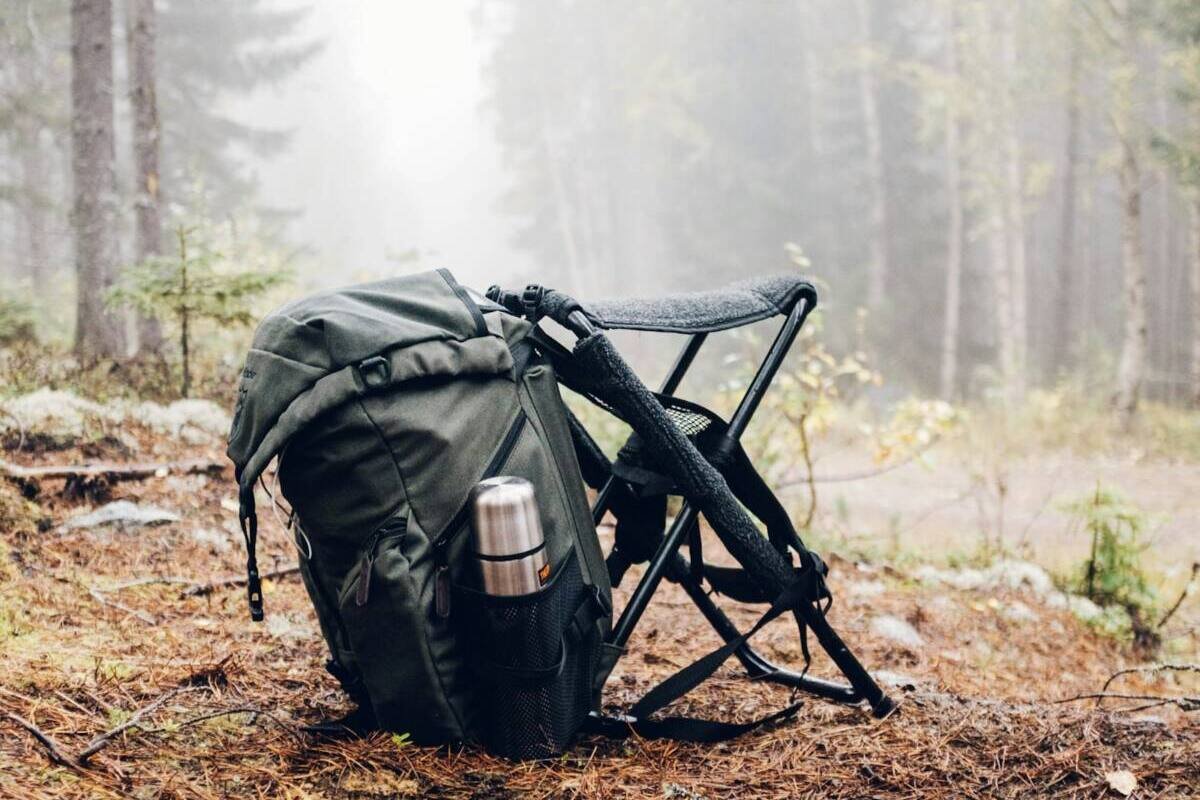Black and gray backpack with a camping chair in the forest