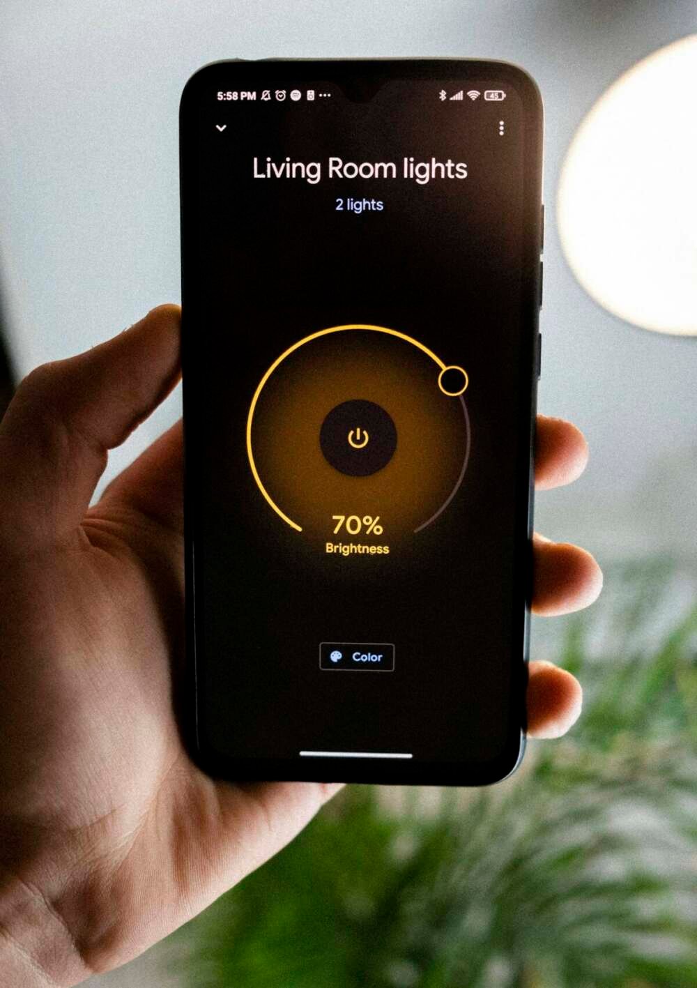 Person holding smartphone controlling smart home app