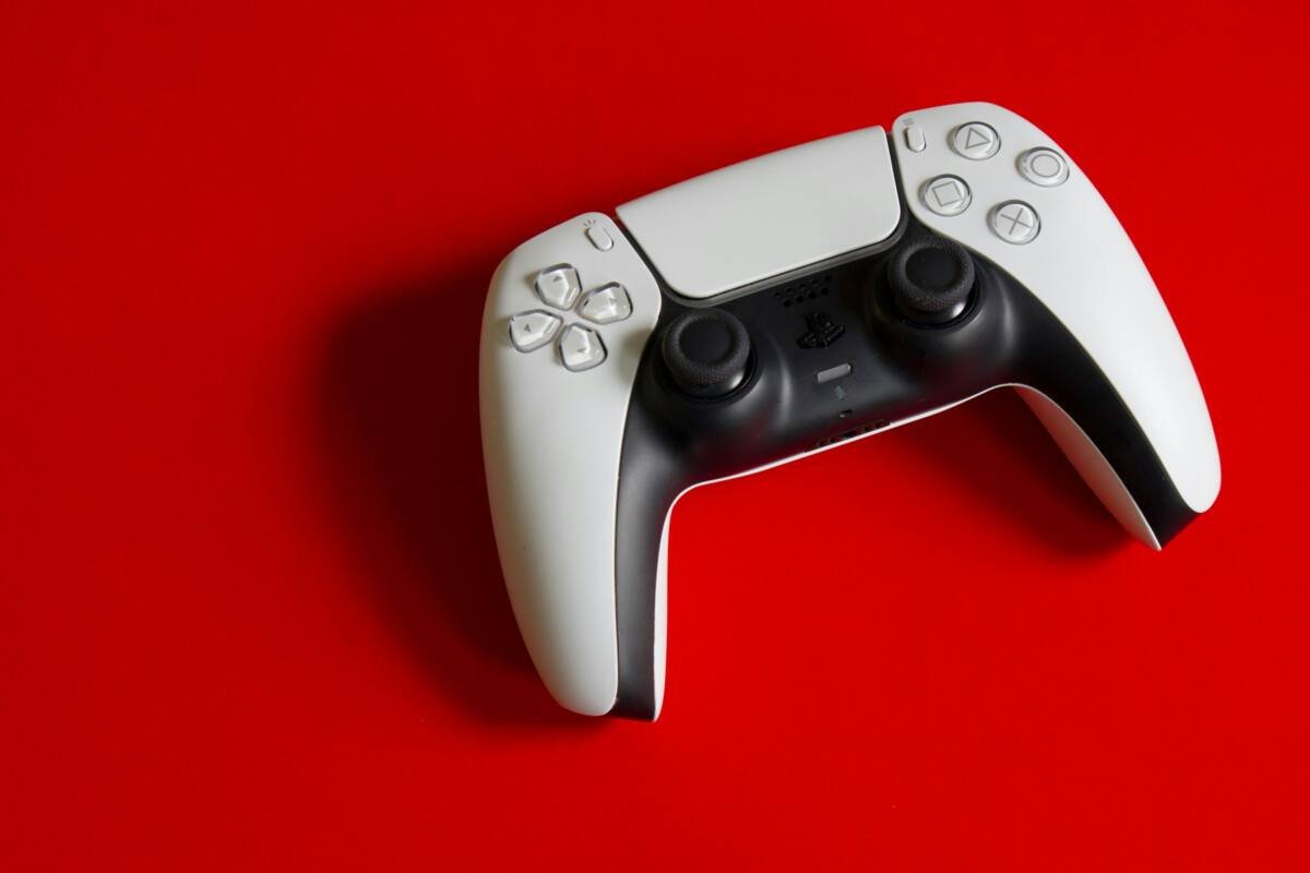 PlayStation 5 DualSense controller on a red surface