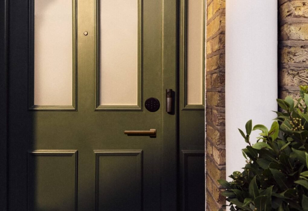 Smart deadbolt lock and video doorbell on a dark green front door