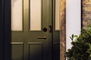 Smart deadbolt lock and video doorbell on a dark green front door