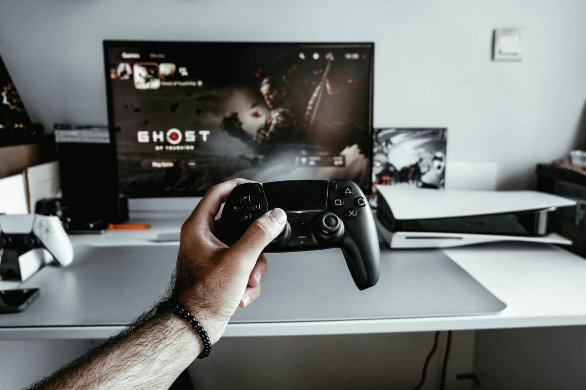 A person holding a video game controller in front of a television