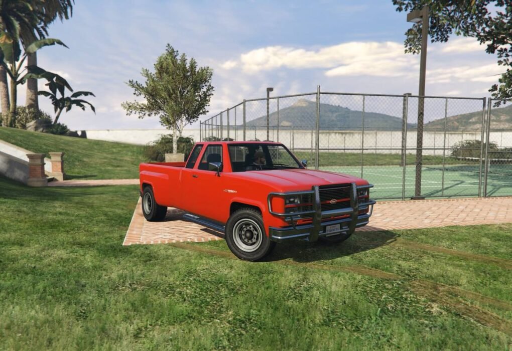 Red Bobcat XL pickup truck with grille guard on grass in GTA V