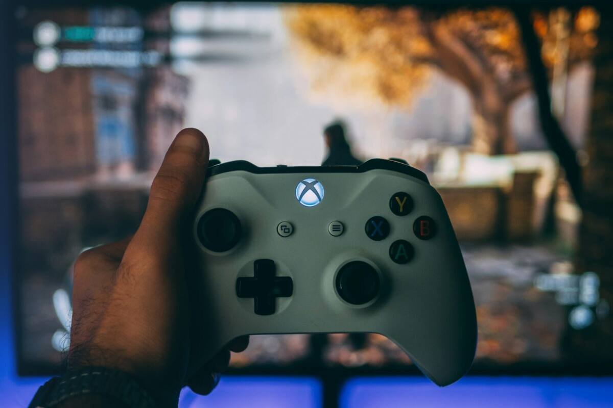 Person holding a white Xbox wireless controller