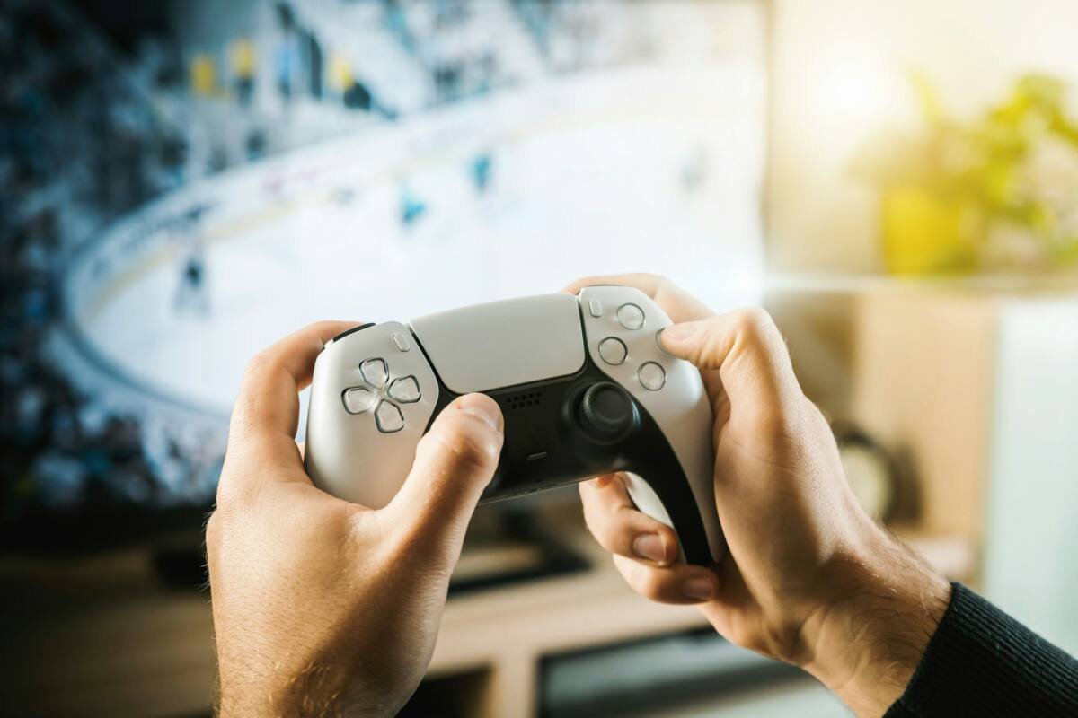 Person playing a console game with a modern gamepad