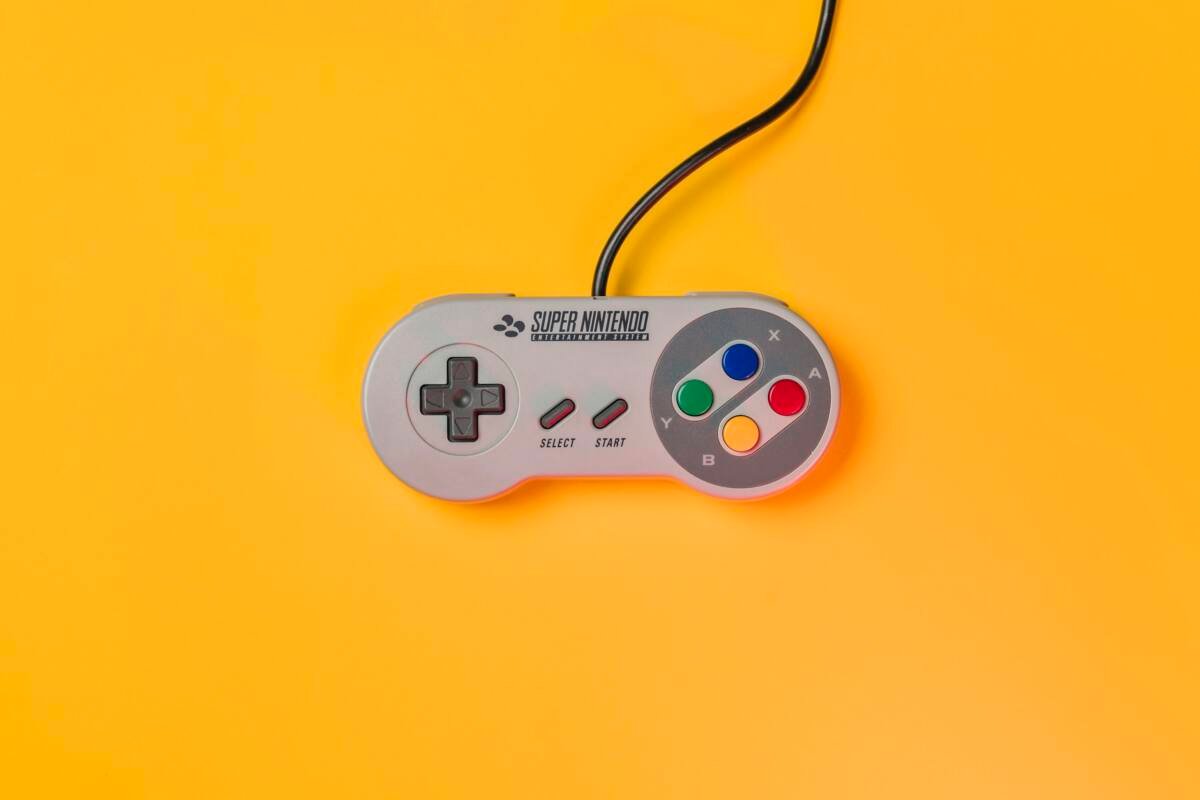 White Nintendo game controller on a yellow surface
